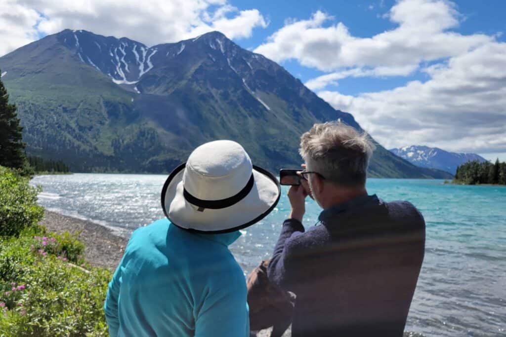 Two people take a photo of the mountains