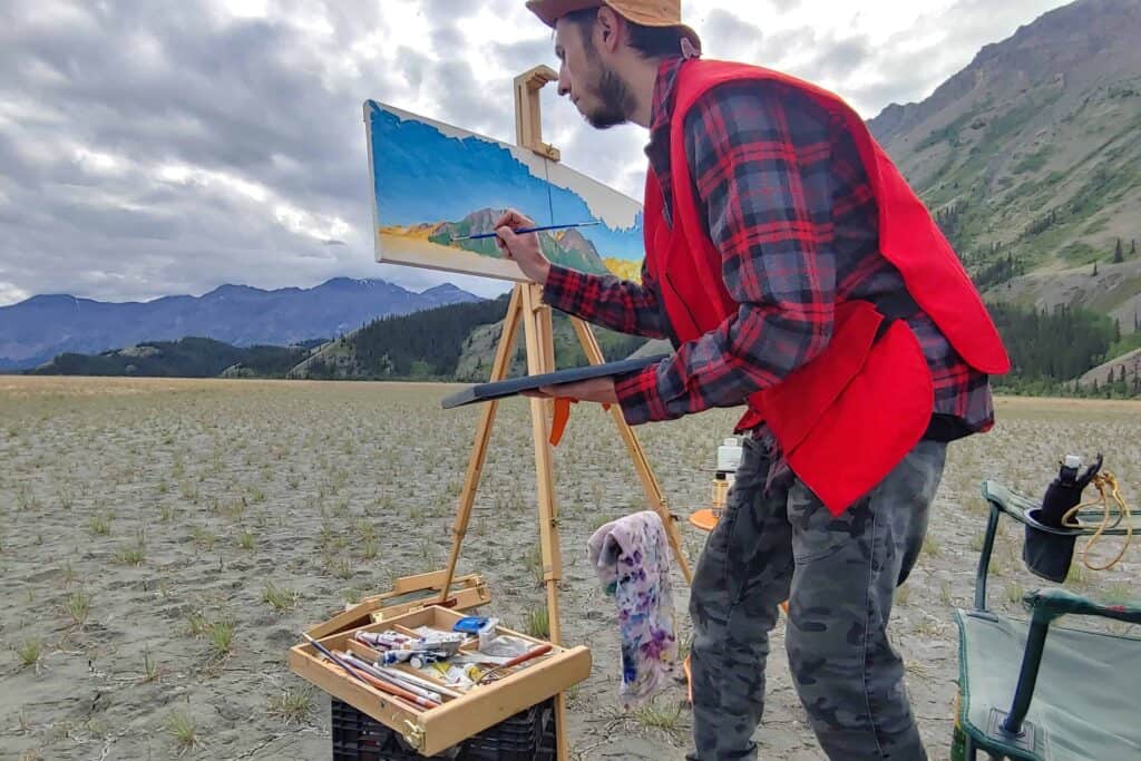 an artist painting an outdoor scenic